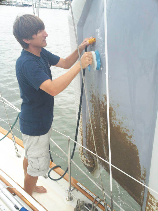 Cleaning the growth off our dinghy. It looks like I need a haircut!